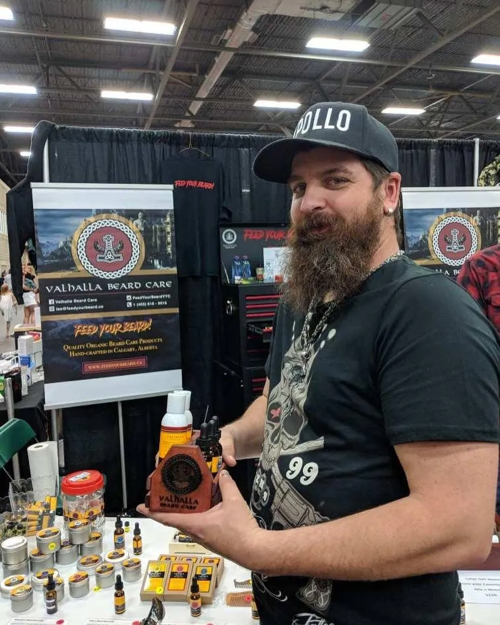 A man holding a bottle of honey at an event.