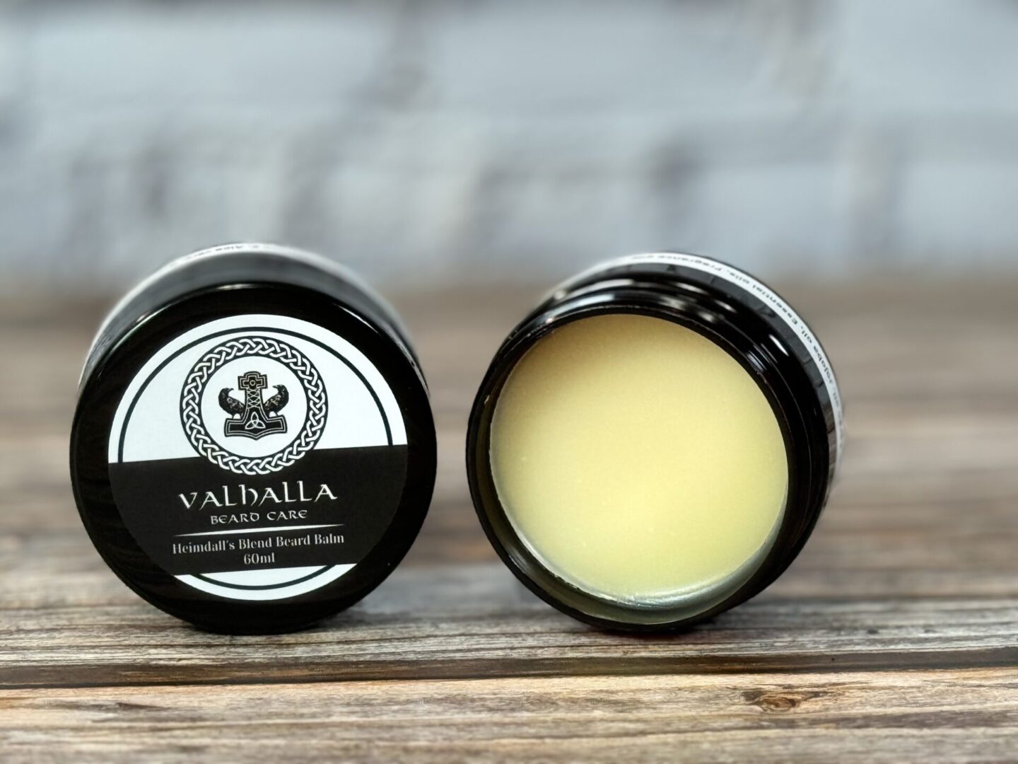 A couple of jars of lip balm sitting on top of a table.