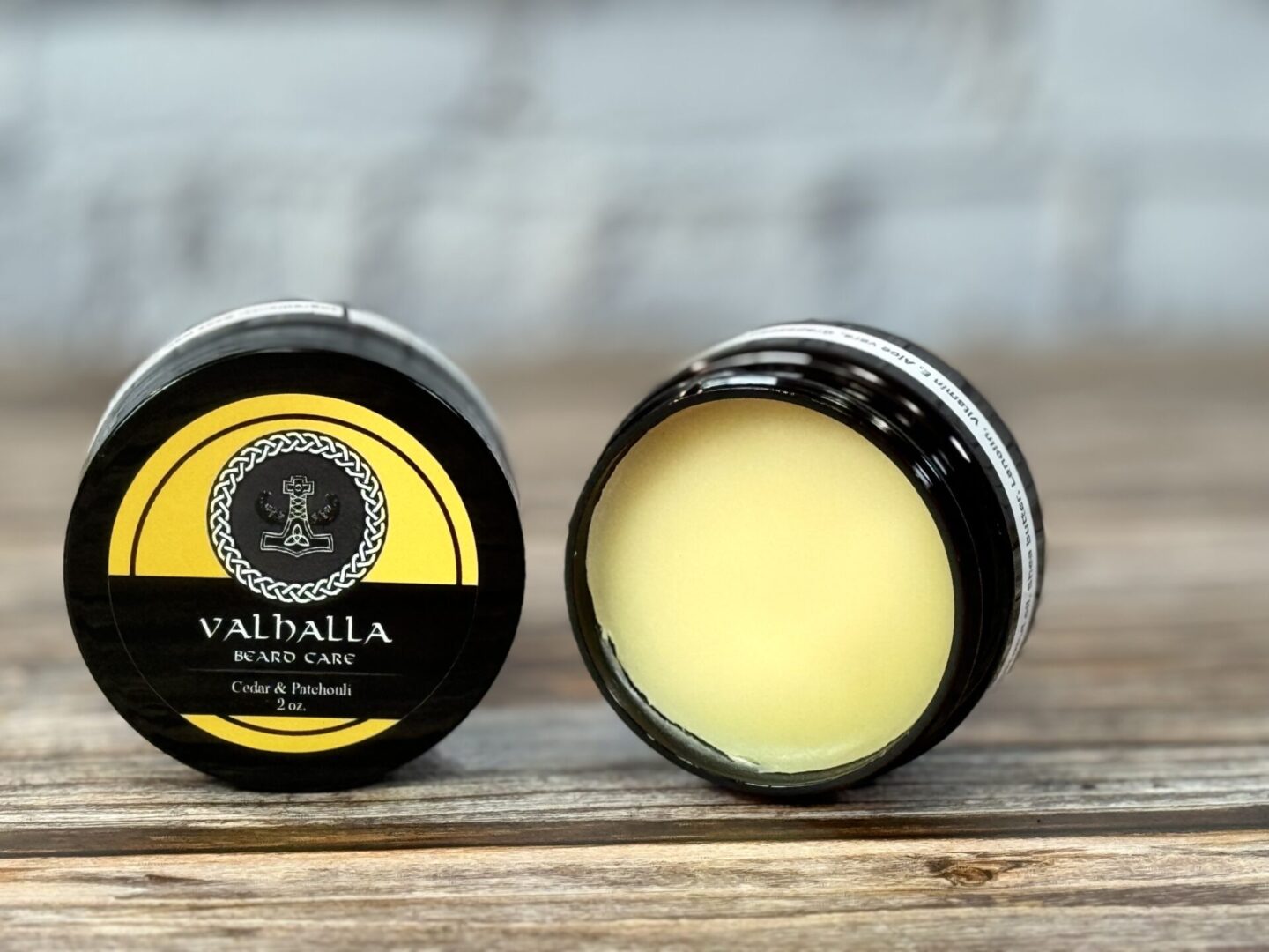 A couple of jars of lip balm sitting on top of a table.