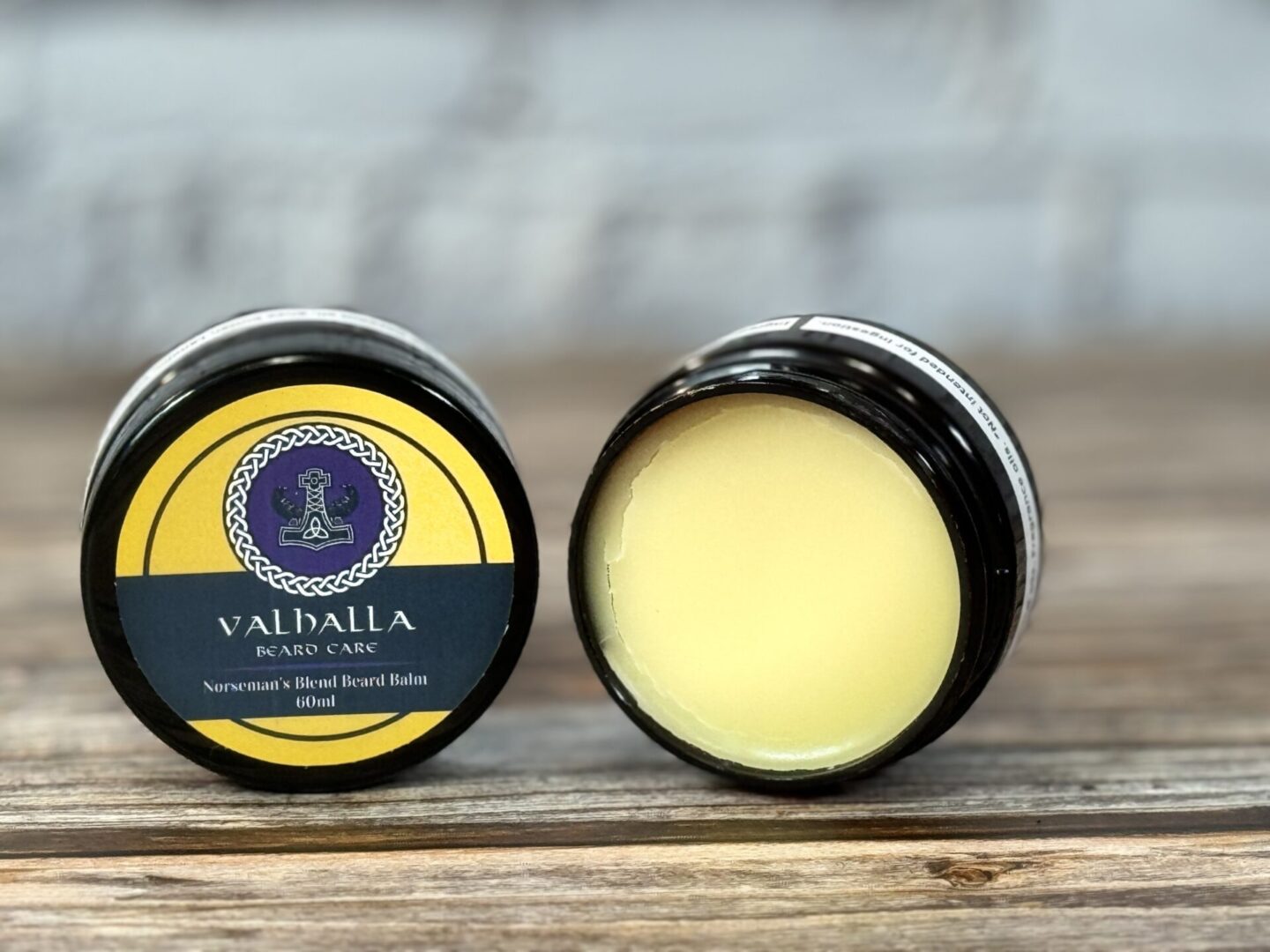 Two small containers of lip balm sitting on top of a table.