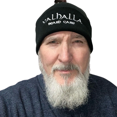 A man with long white beard wearing a black hat.