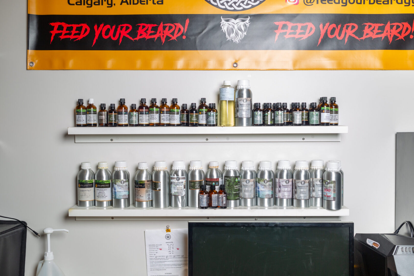 A wall with many bottles of beard oil on it.