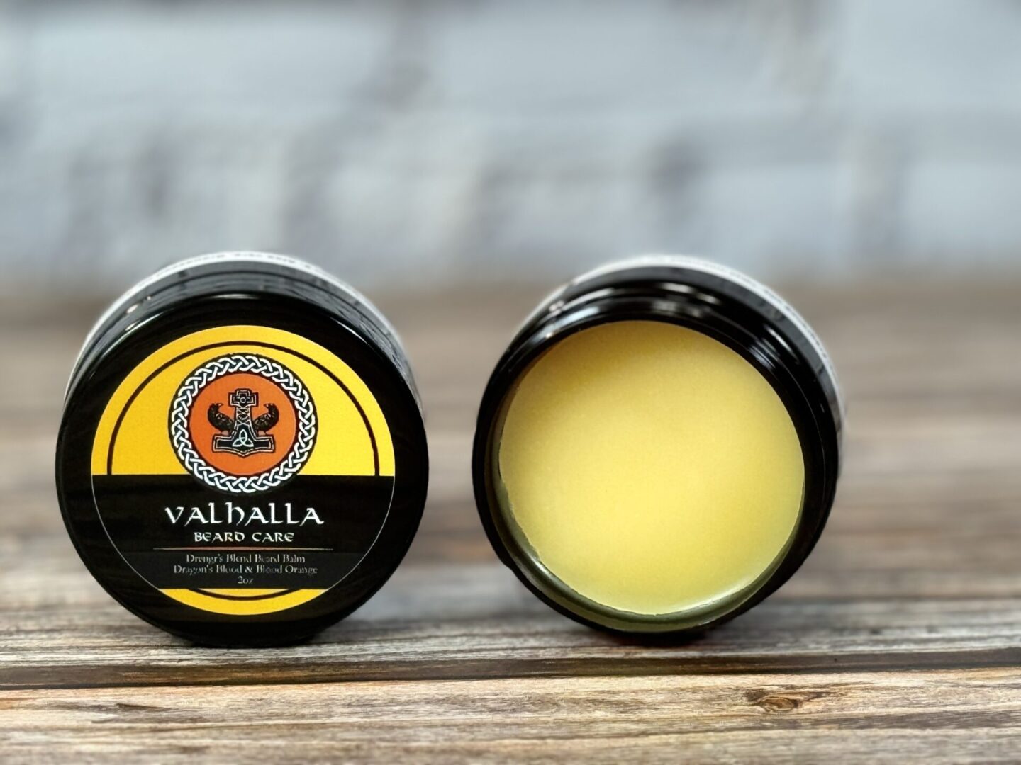 A close up of two containers of balm