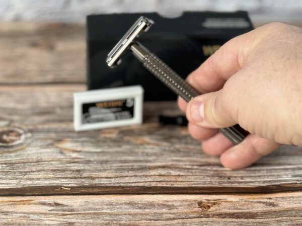 A person holding a razor blade in their hand.